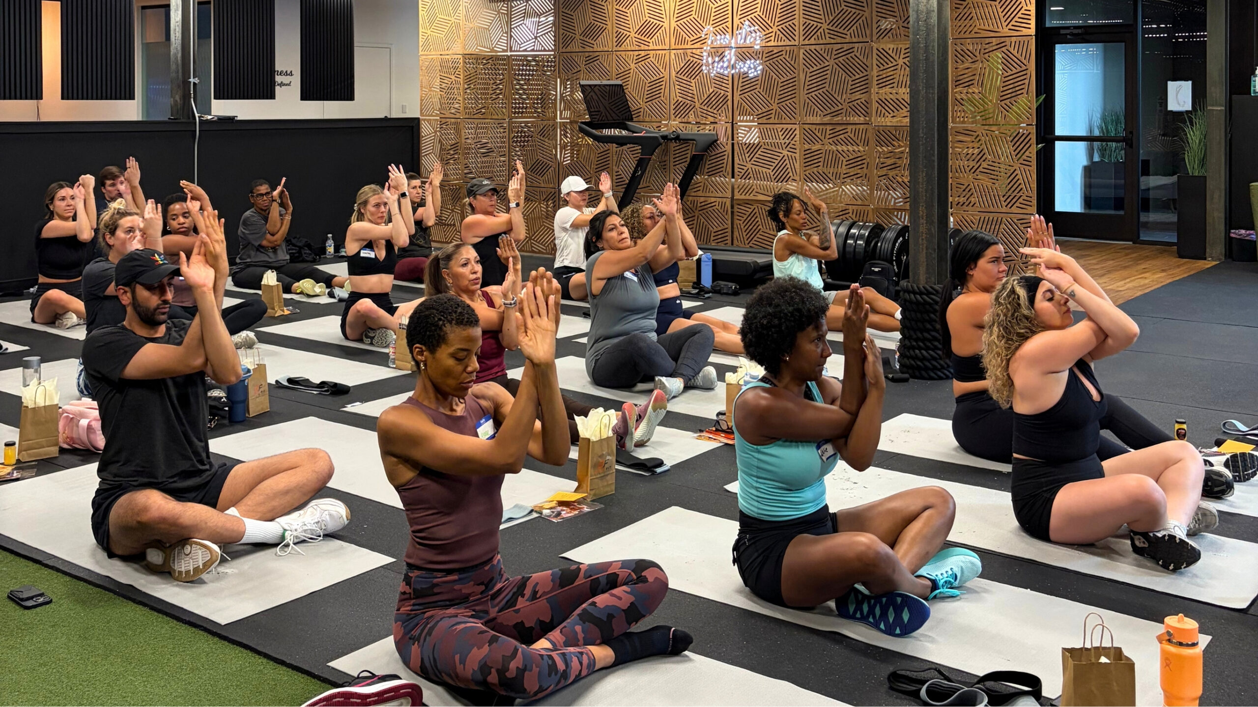 Attendees following an instructor during a guided stretching session at a Denver wellness event.