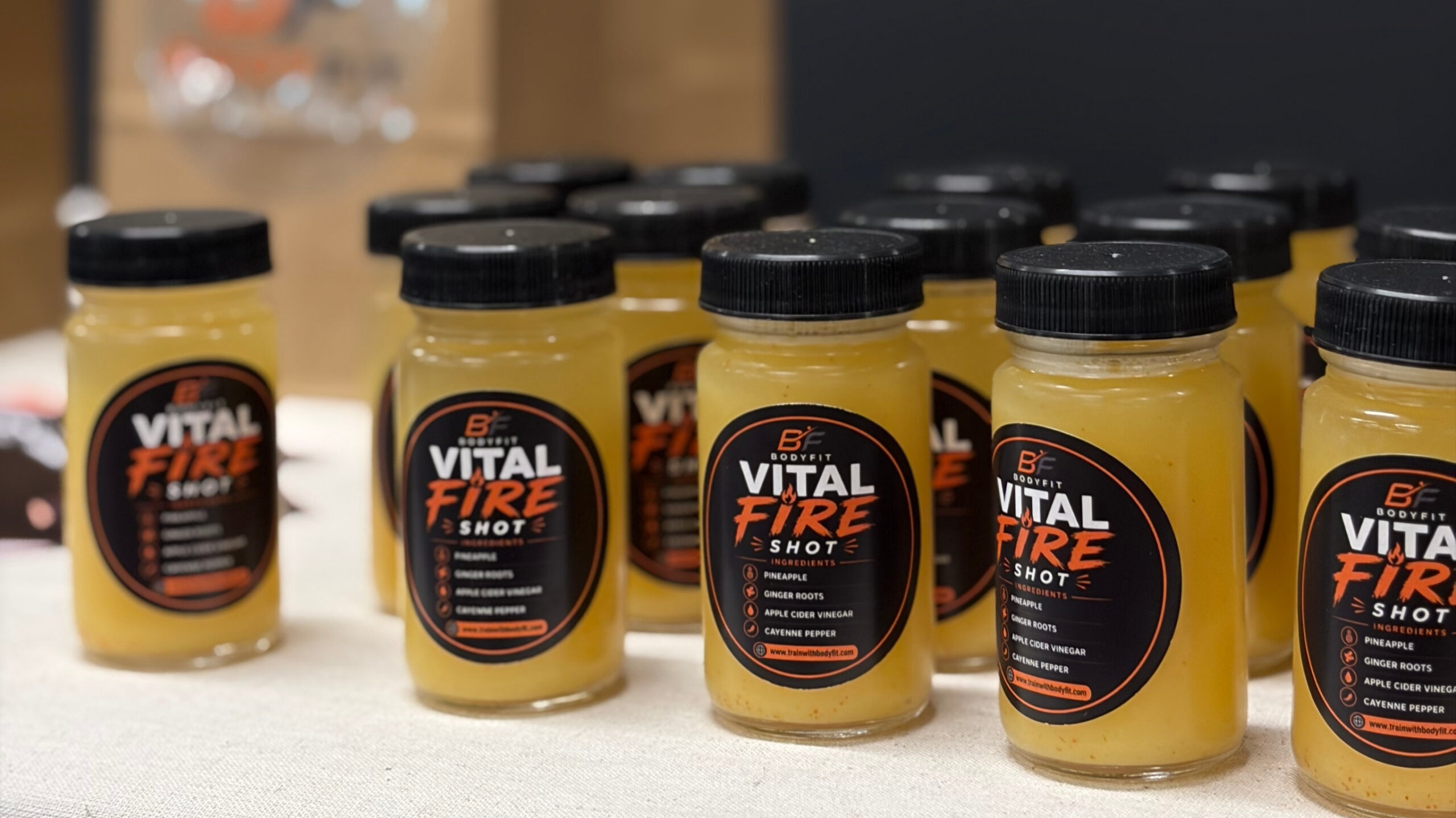 A close-up of a wellness ginger shot drink being served at a Denver health event.