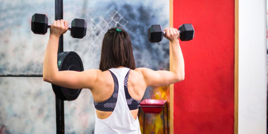 Woman strength training with dumbbells during a GLP-1 weight loss journey.